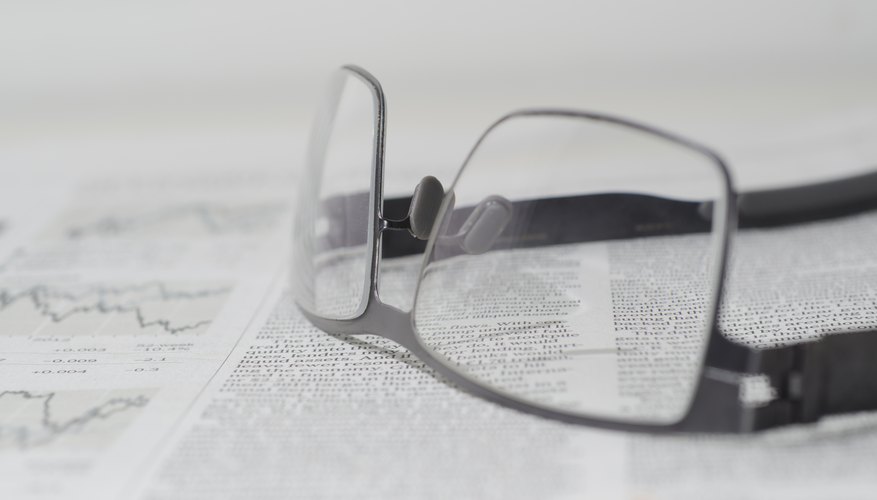 Pair of glasses sitting on top of the stocks page