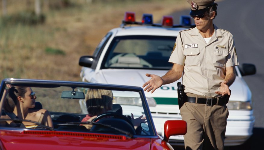 Policeman talking to a young couple sitting in a car