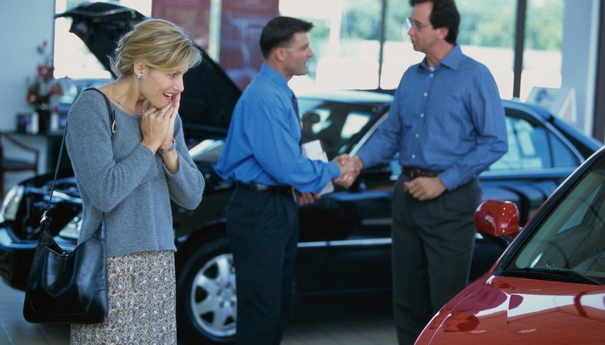 Mid adult woman looking at a car in a car showroom