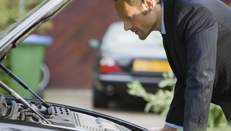 Man looking under hood of car