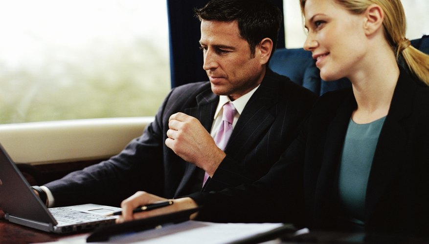 Businessman and businesswoman working on train