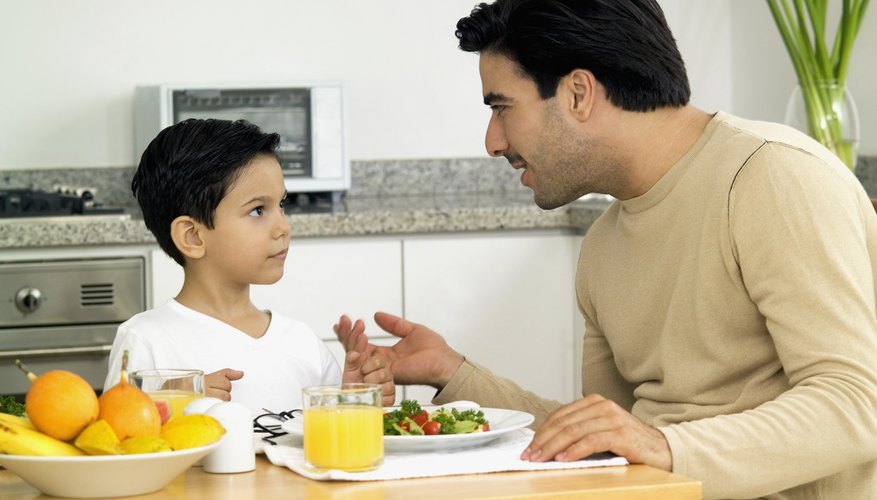 Father talking to his son at the breakfast table. Father talking to his son at the breakfast table.