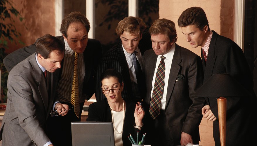 Business people looking at laptop screen in office