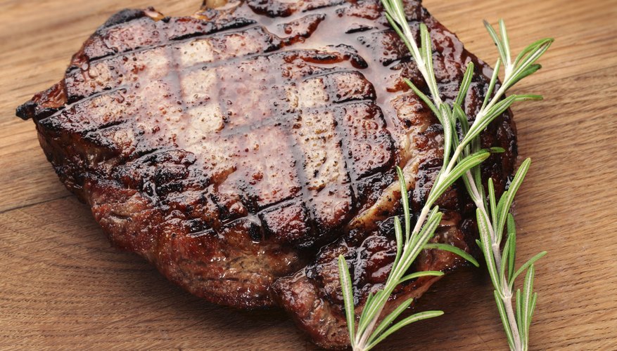 A grilled steak on a cutting board. A grilled steak on a cutting board.