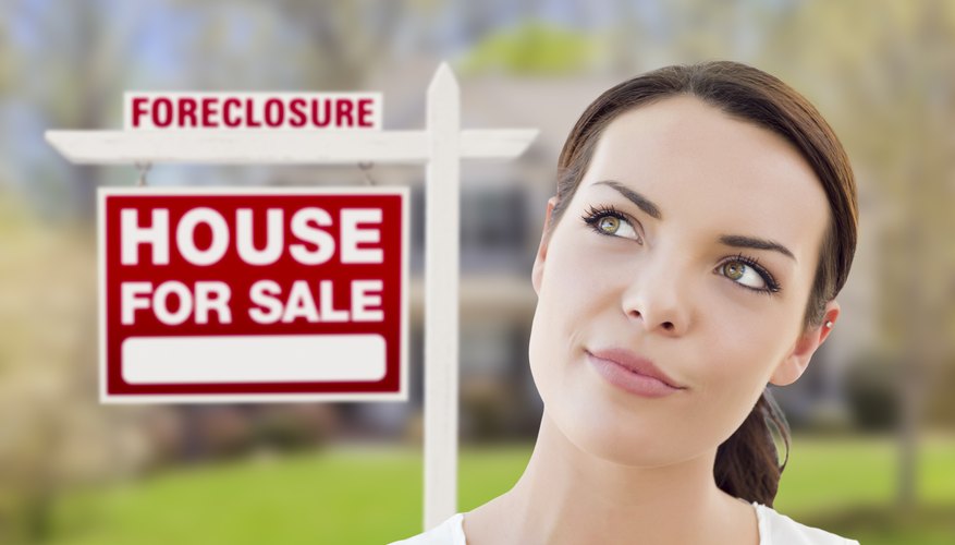 Woman in front of foreclosure house for sale sign