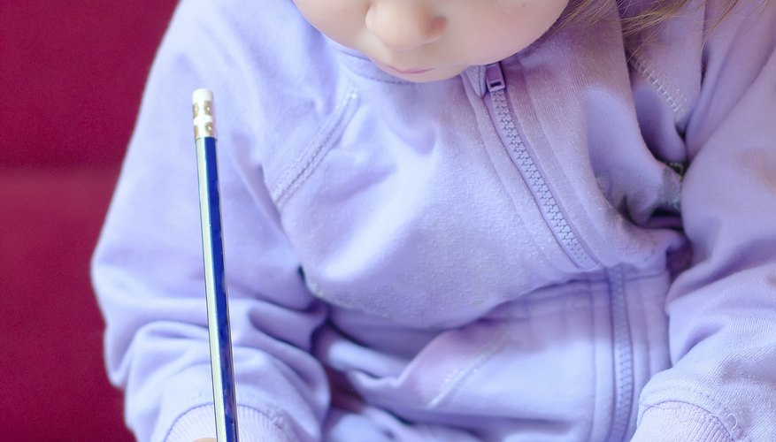 A toddler places his hand on a piece of paper. A toddler places his hand on a piece of paper.