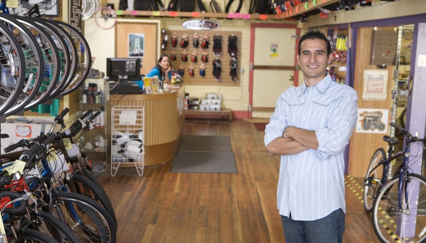 Proud business owner with arms crossed in bike shop