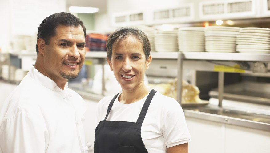 Portrait of a male chef smiling with a female chef