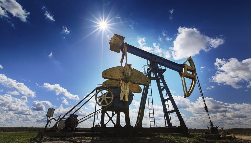 Operating oil and gas well profiled on cloudy sky
