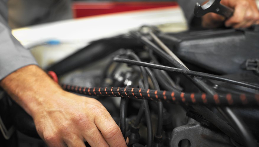 Close up of an car engine being repaired by a male mechanic holding a spanner