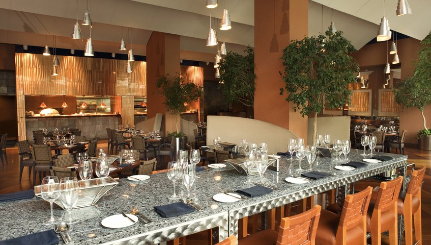 Photo Credit: Jupiterimages/Stockbyte/Getty Images An interior of a restaurant shows a high marble bar with wooden chairs to offer a casual but sleek aesthetic