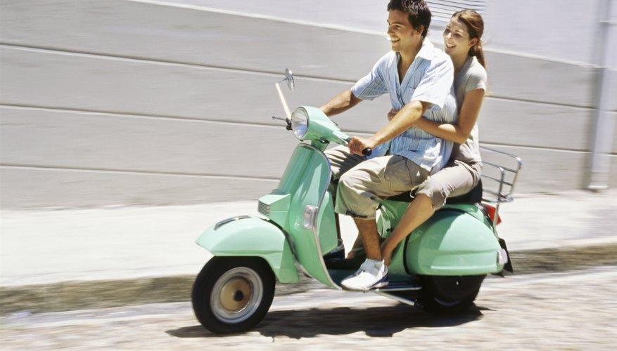 Young couple riding on a scooter and smiling