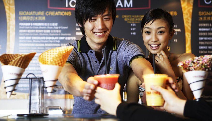 Photo Credit: Sky View/Photodisc/Getty Images Man and woman buying drinks at a food stand