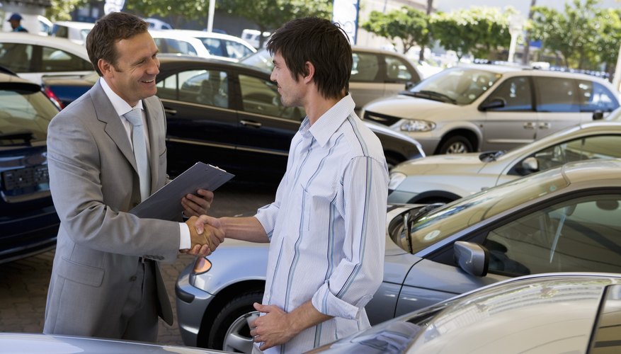 Salesman showing man a car