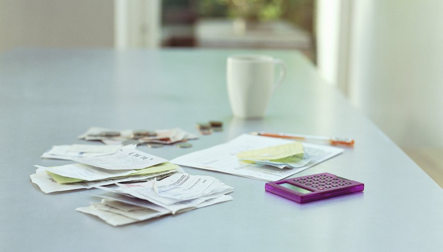Receipts, money, a document and calculator on a desk.
