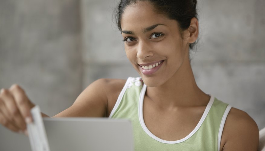 Smiling young woman holding a credit card.