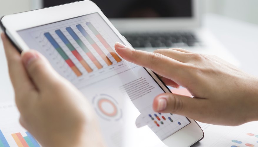 Close-up of business person using digital tablet with financial