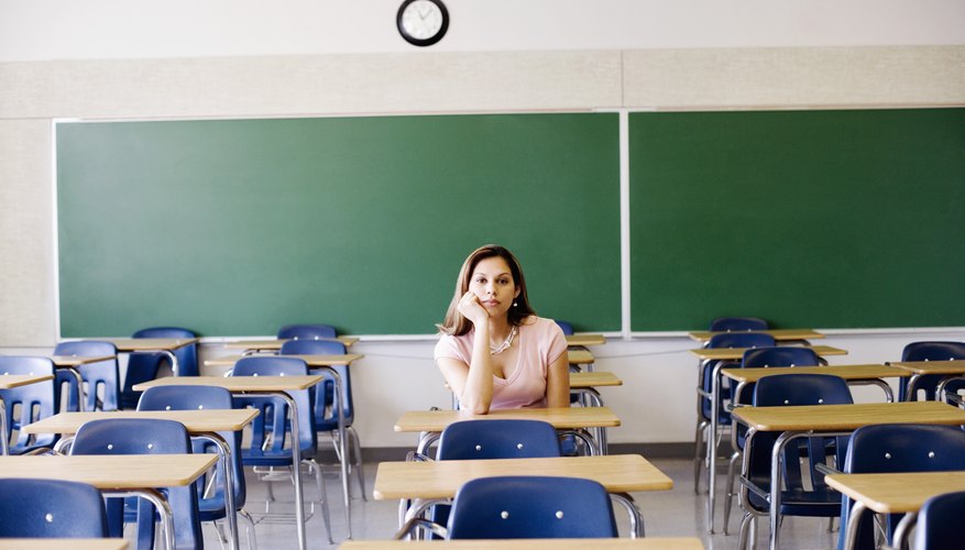 Woman sitting in classroom at desk. Woman sitting in classroom at desk.