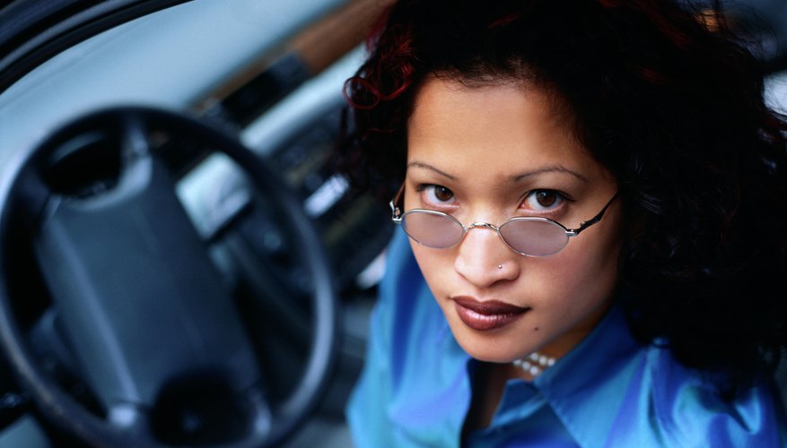 Close-up of woman sitting in car door opened