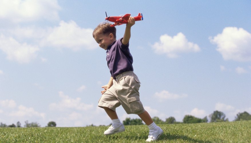 Kid playing with toy airplane on the grass. Kid playing with toy airplane on the grass.