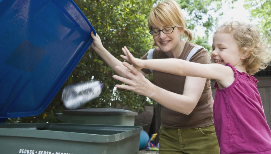 Photo Credit: Thinkstock Images/Stockbyte/Getty Images Two siblings tossing a plastic bottle into a recycling bin.