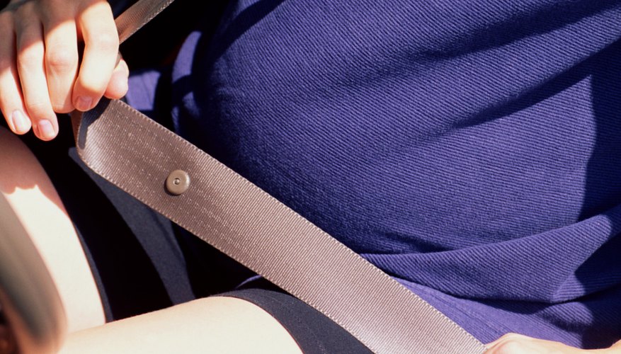 Pregnant woman adjusting seatbelt