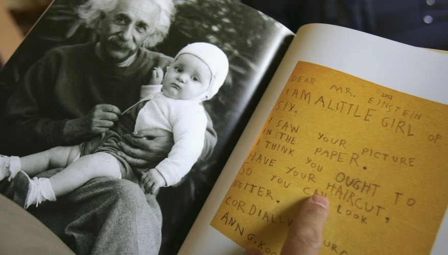 A photo of Albert Einstein with a baby and a letter in a booklet. A photo of Albert Einstein with a baby and a letter in a booklet.