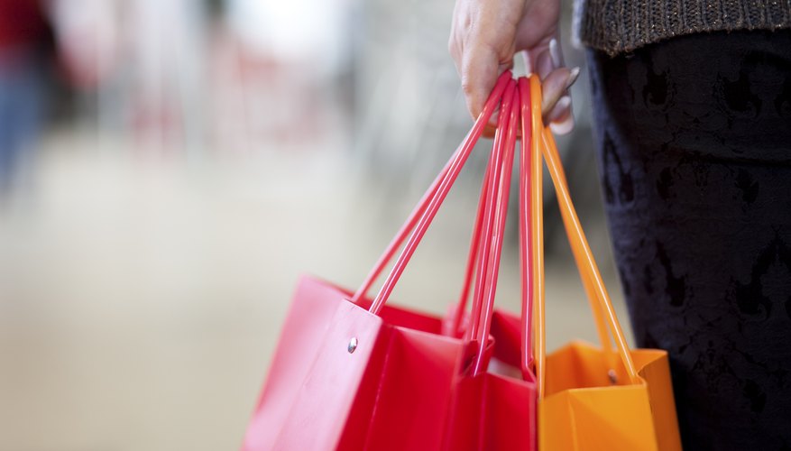 Photo Credit: hoozone/iStock/Getty Images A woman is holding a gift bag in her hand.