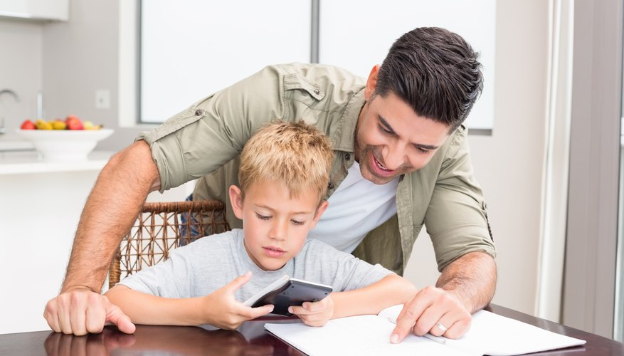 Photo Credit: Wavebreakmedia Ltd/Wavebreak Media/Getty Images Image of father and son doing a math problem.