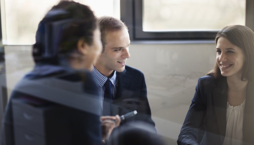 Three business people sitting and discussing at a business meeting