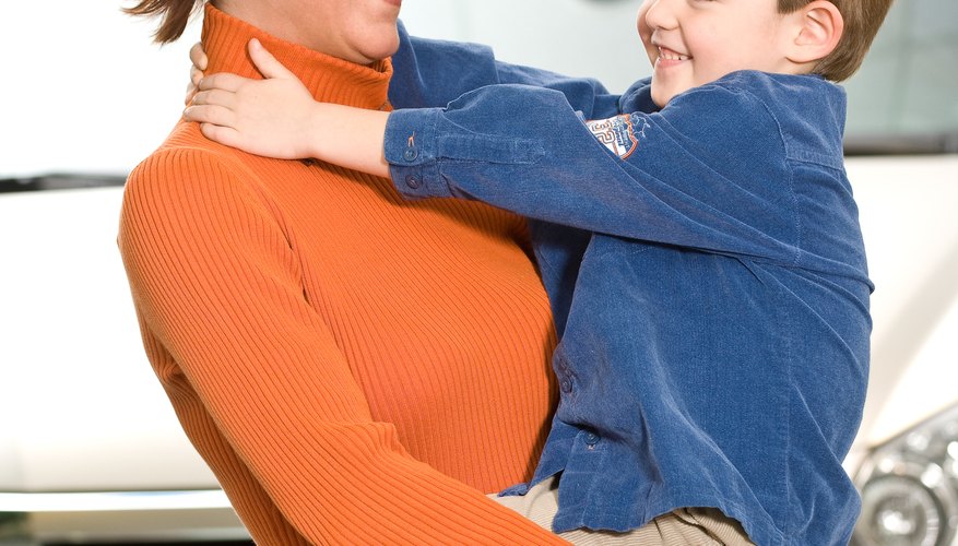 Mother holding son in new car showroom