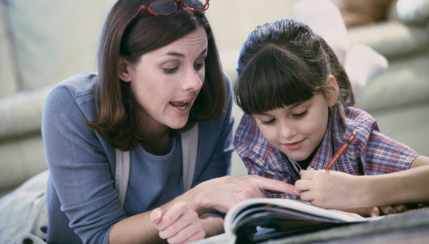 Mother helping daughter with workbook assignment at home. Mother helping daughter with workbook assignment at home.