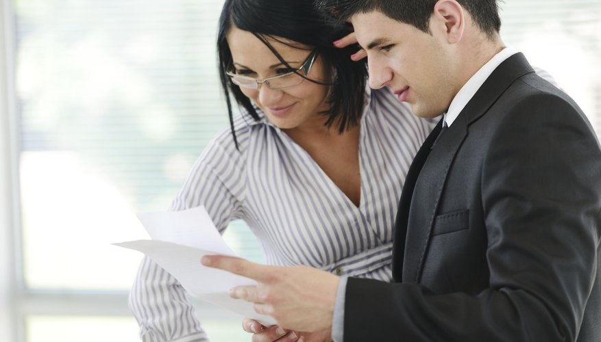Businessman and businesswoman reading a report at workplace