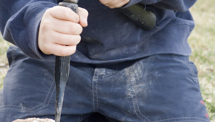 Photo Credit: Tammy Bryngelson/iStock/Getty Images Use a hammer to assist the chisel as you break through.