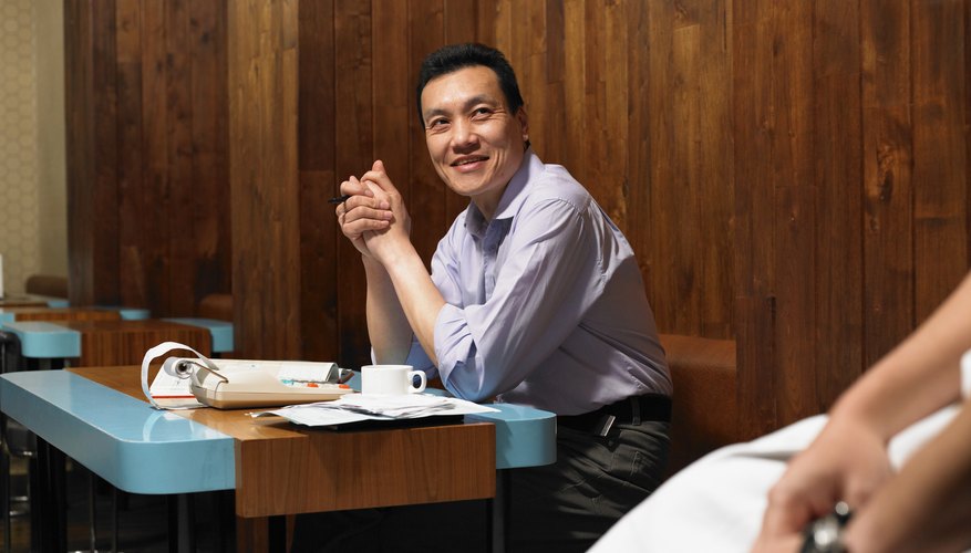 Photo Credit: Michael Blann/Digital Vision/Getty Images Manager sitting in restaurant going over paperwork