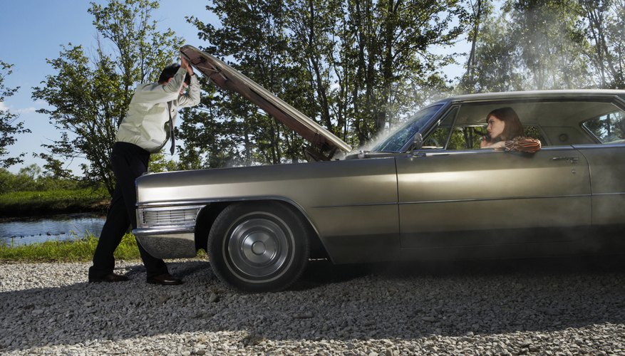 Woman in car, man looking under hood, side view