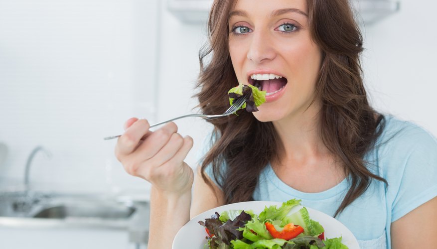 Young woman taking a bite of her salad. Young woman taking a bite of her salad.