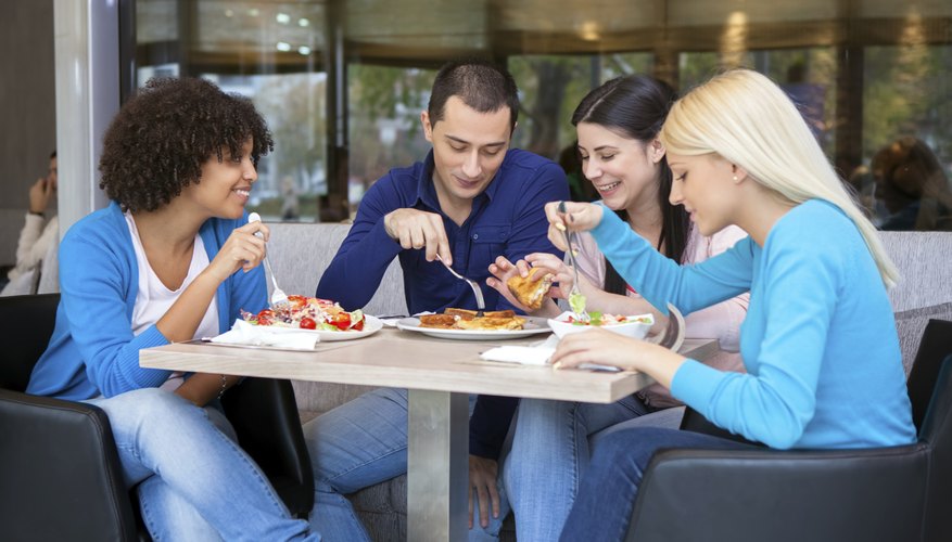 Cheerful teenagers having lunch in restaurant