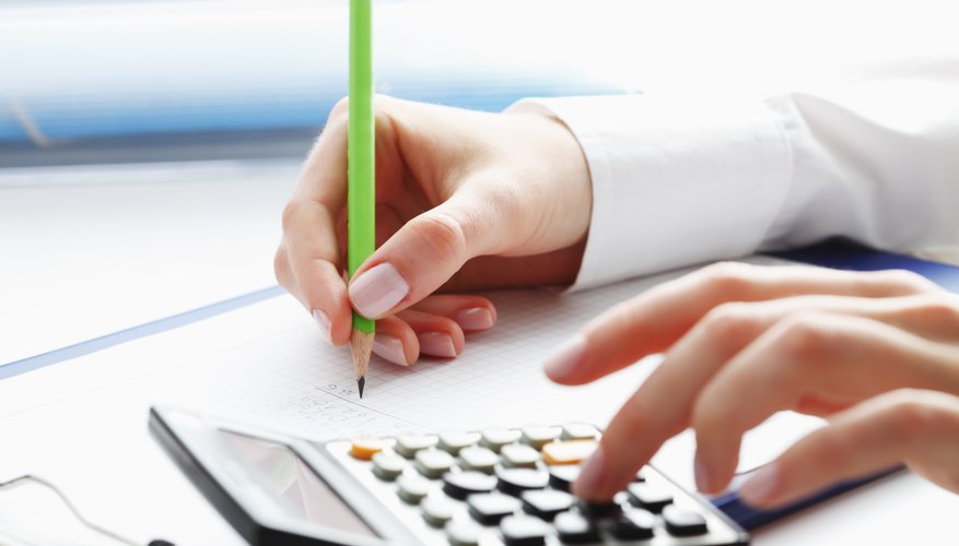Financial data analyzing. Counting on calculator.