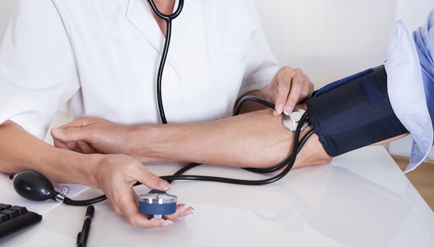 Nurse tests patient blood pressure Nurse tests patient blood pressure