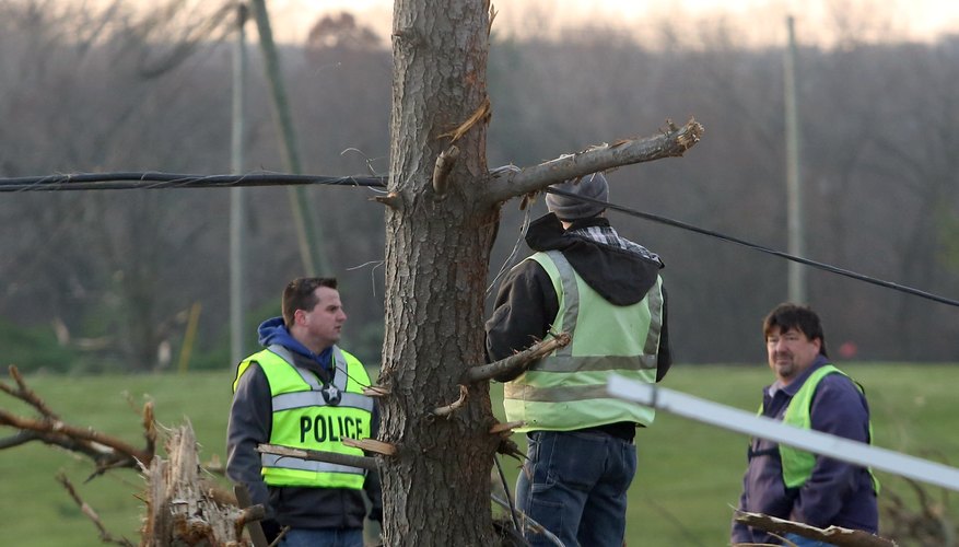 Photo Credit: Tasos Katopodis/Getty Images News/Getty Images Police officers deal with live electrical wires due to a tornado.