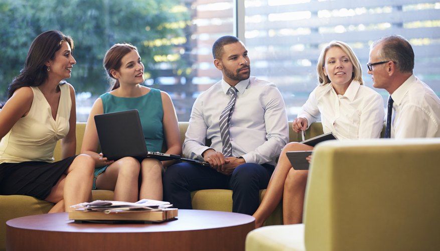 Group Of Businesspeople Having Meeting In Office Lobby