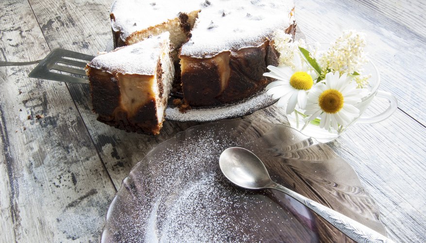 Cheesecake on a glass dish whith bouquet of chammomile