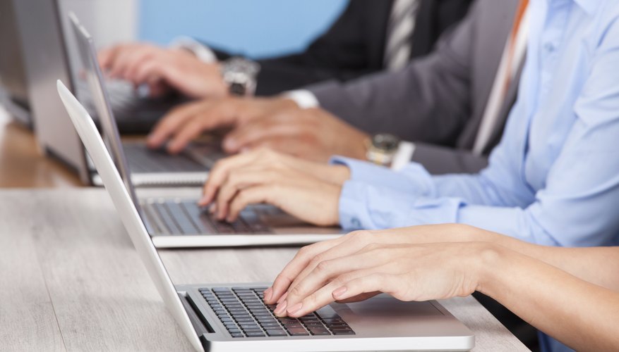 Close-up Of Businesspeople Using Laptop