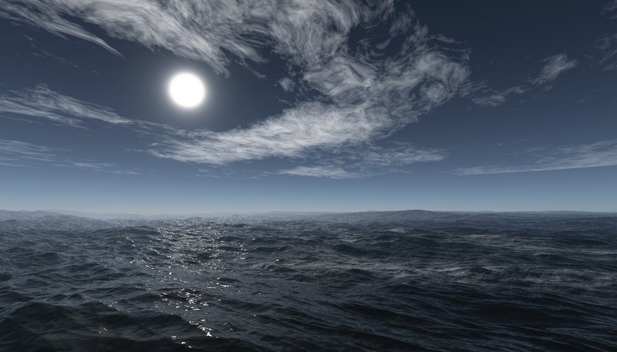 A moon rises over an ocean. A moon rises over an ocean.
