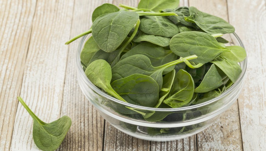 Glass bowl filled with baby spinach Glass bowl filled with baby spinach