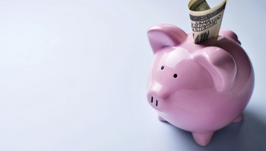 Pink piggy bank with a dollar bill in the slot