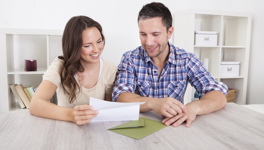 A man and woman are looking at a personal check.