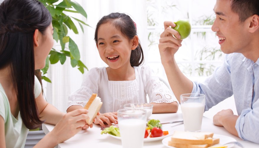 Parents speaking with child at breakfast table. Parents speaking with child at breakfast table.