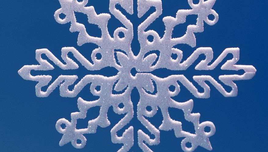 Recorta copos de nieve para ilustrar el concepto de los ejes de simetría.